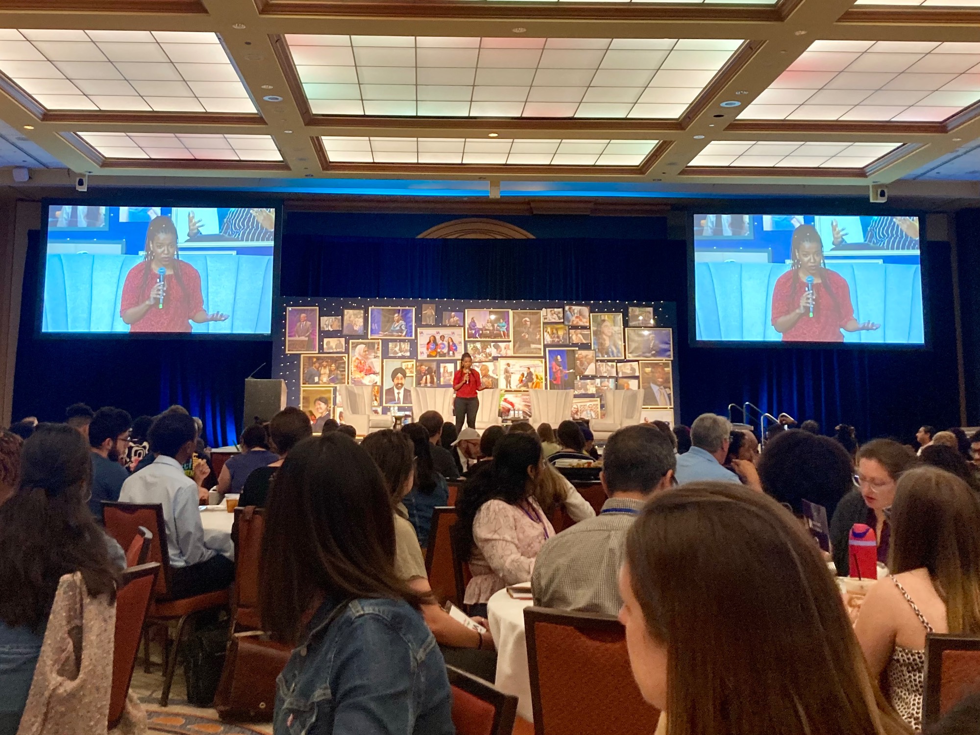 Woman on a stage in front of a ballroom of students and adults